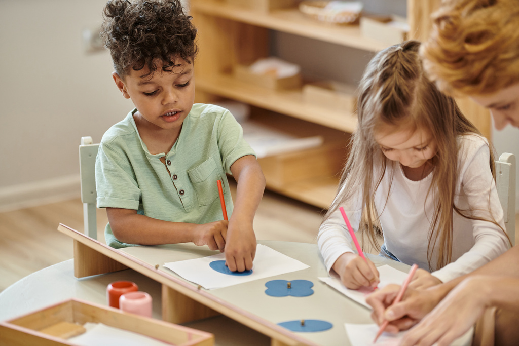 african american boy painting near friend and blurred teacher in montessori school - Photo, Image