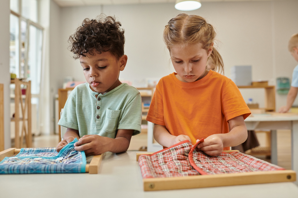 Multiethnische Kinder knöpfen in der Montessori-Schule Stoffe an Rahmen - Foto, Bild