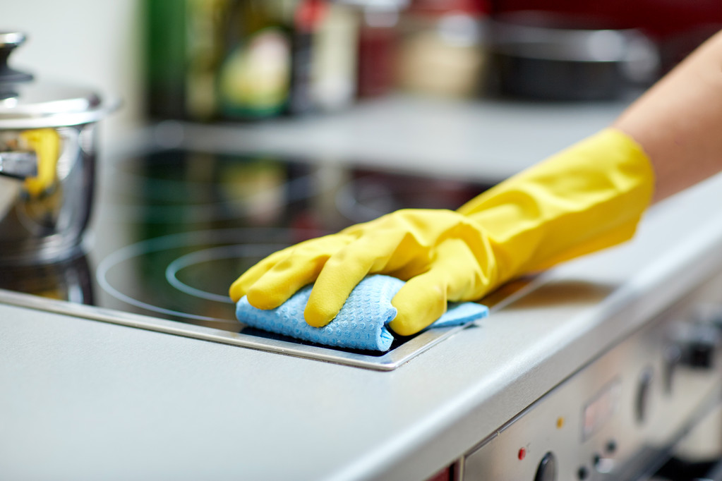 Primo piano della donna pulizia fornello a casa cucina
 - Foto, immagini