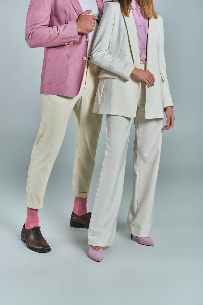 обрізаний вид пари в елегантному і стильному діловому вбранні, що стоїть на сірому, формальному одязі - Фото, зображення