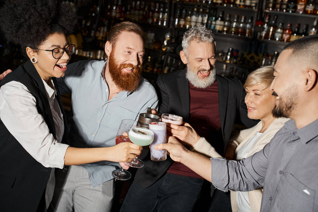 Kokteyl barında kurumsal parti, neşeli çoklu etnik meslektaşlar içki bardaklarını tokuşturuyor. - Fotoğraf, Görsel