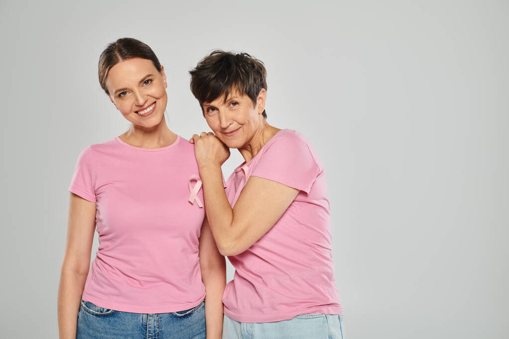 koncepce povědomí o rakovině prsu, šťastné ženy s růžovými stuhami na šedém pozadí, bez rakoviny - Fotografie, Obrázek