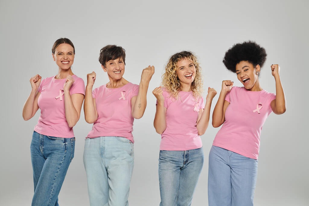 ευαισθητοποίηση του καρκίνου του μαστού, ενθουσιασμένες διαφυλετικές γυναίκες με ροζ κορδέλες στο γκρι, ποικιλομορφία, χωρίς καρκίνο - Φωτογραφία, εικόνα