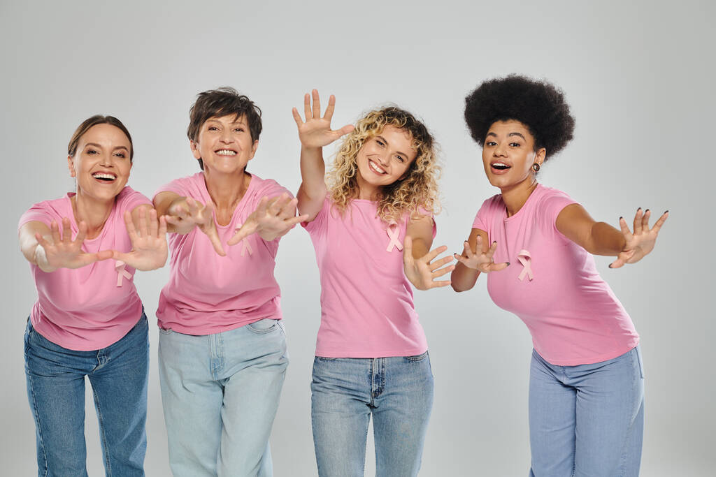 povědomí o rakovině prsu, radostné mezirasové ženy s růžovými stuhami na šedi, různorodost, bez rakoviny - Fotografie, Obrázek