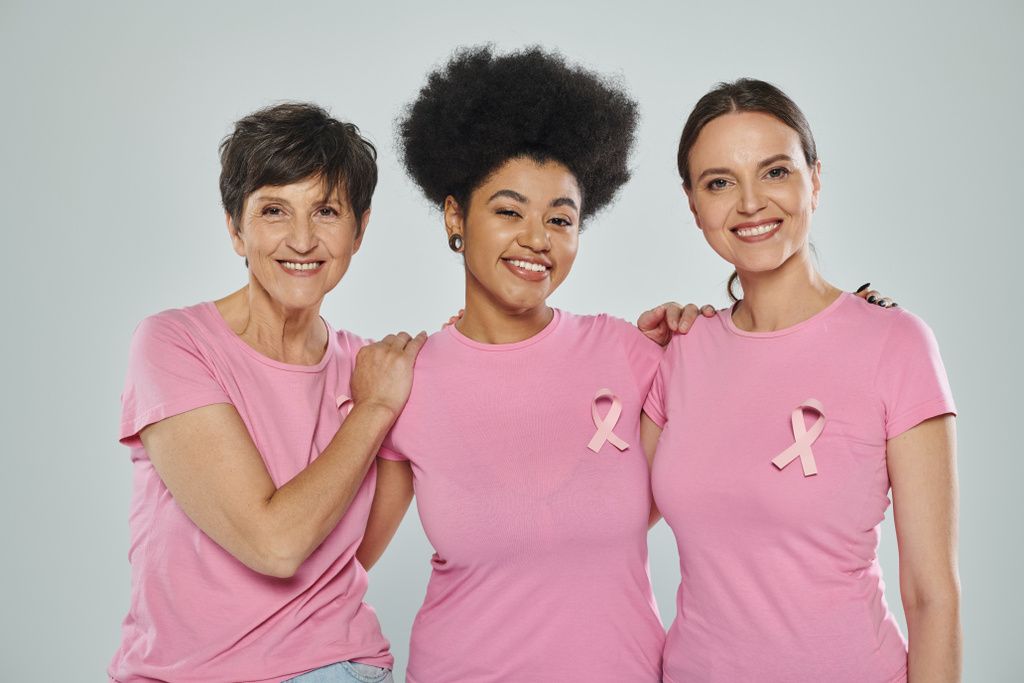 świadomość raka piersi, międzyrasowe kobiety uśmiechnięte na szarym tle, różne pokolenia, portret - Zdjęcie, obraz