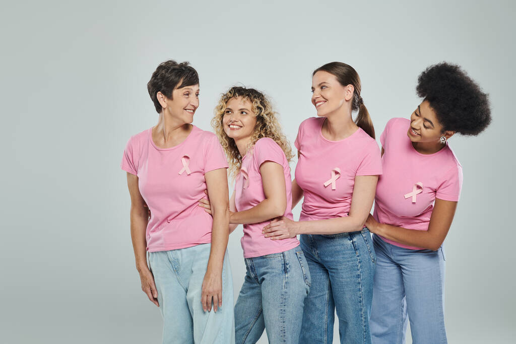 multicultural women different age smiling on grey backdrop, support, breast cancer awareness - Photo, Image