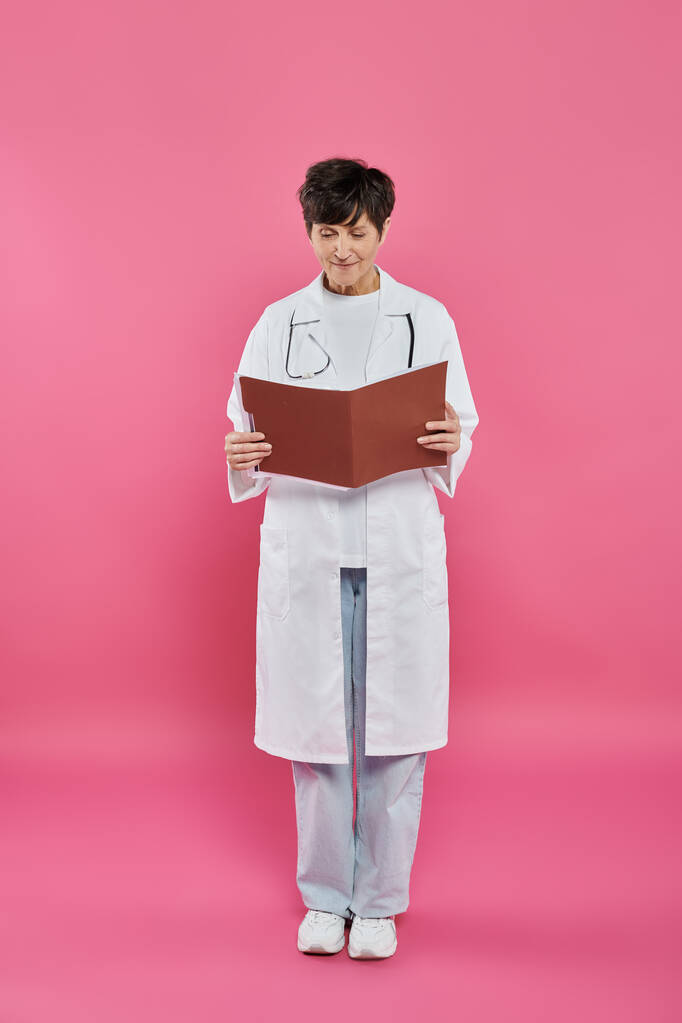 female oncologist, mature doctor holding folder, breast cancer awareness concept, medical record - Photo, Image