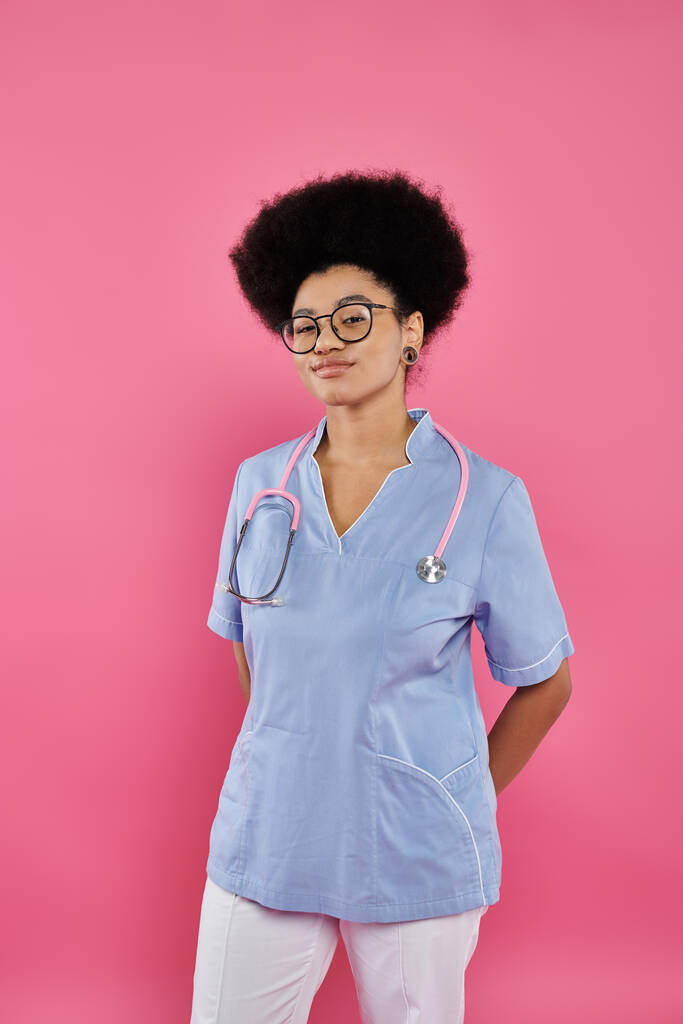 emlőrák tudatosság, afro-amerikai női orvos, onkológus sztetoszkóppal, rózsaszín háttér - Fotó, kép