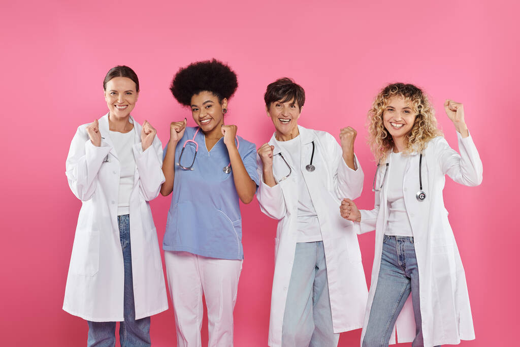 grupo de oncologistas multiétnicos excitados mostrando sim gesto isolado em rosa, câncer de mama mês - Foto, Imagem