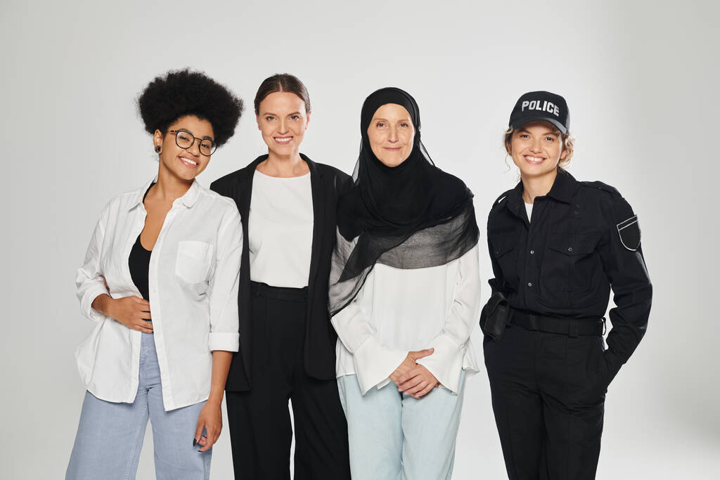 fröhliche Gruppe multiethnischer Frauen posiert isoliert auf grau - Foto, Bild