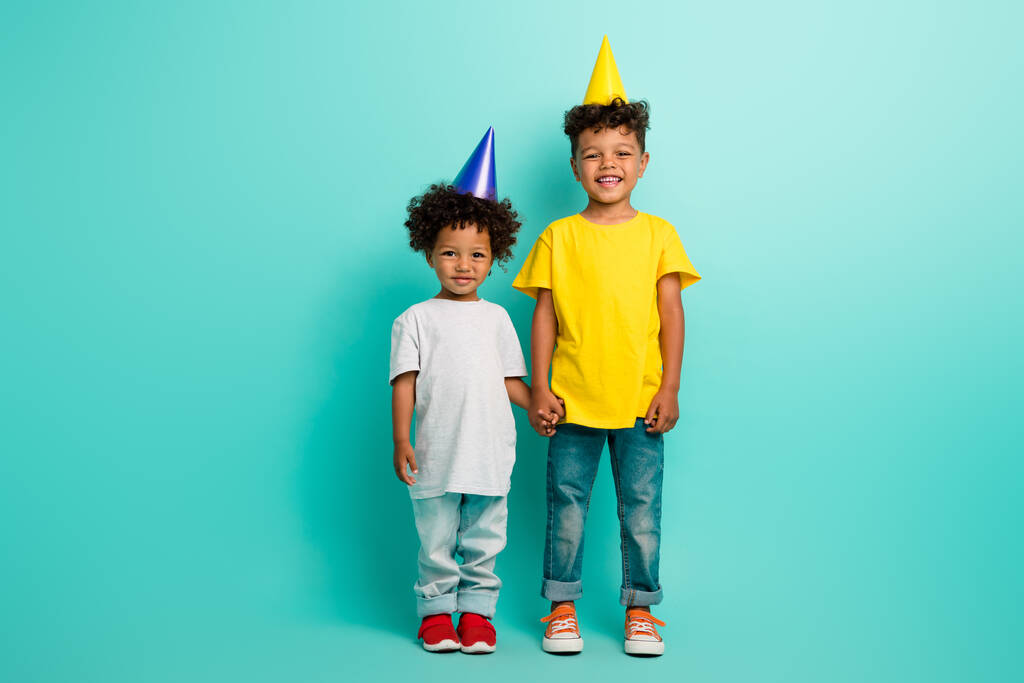 Plná velikost fotografie roztomilých malých chlapců bratři držet ruce Happy birthday oblečený stylový outfit izolované na azurové barvy pozadí. - Fotografie, Obrázek