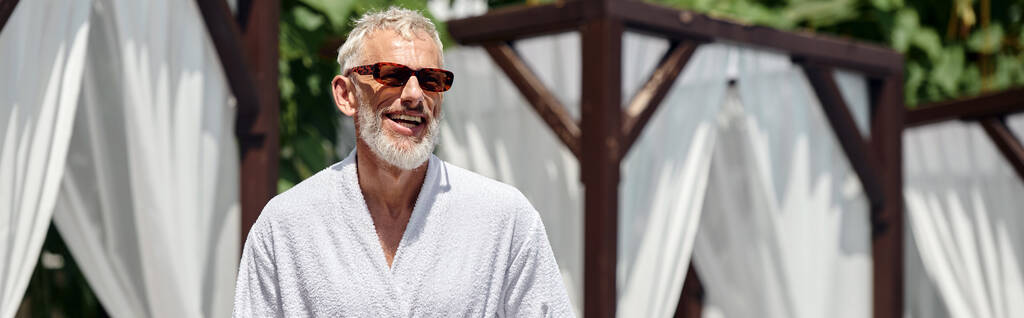 hombre alegre de mediana edad en gafas de sol elegantes tomar el sol en un resort de lujo, bandera horizontal - Foto, imagen