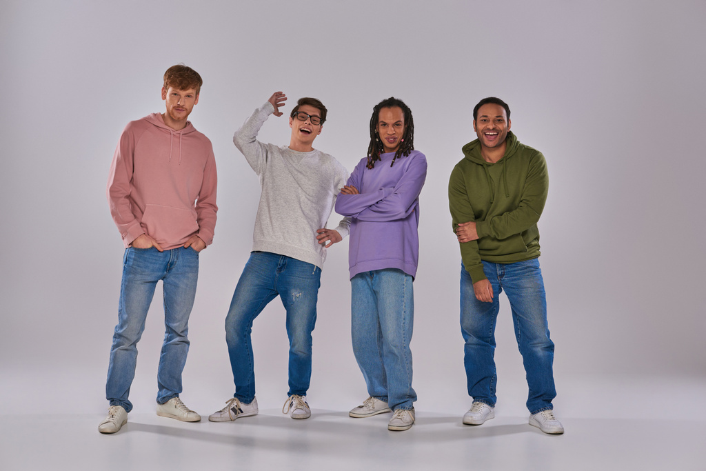 négy fiatal multikulturális férfi alkalmi ruhákban áll és nevet a kamerán, kulturális sokszínűség - Fotó, kép