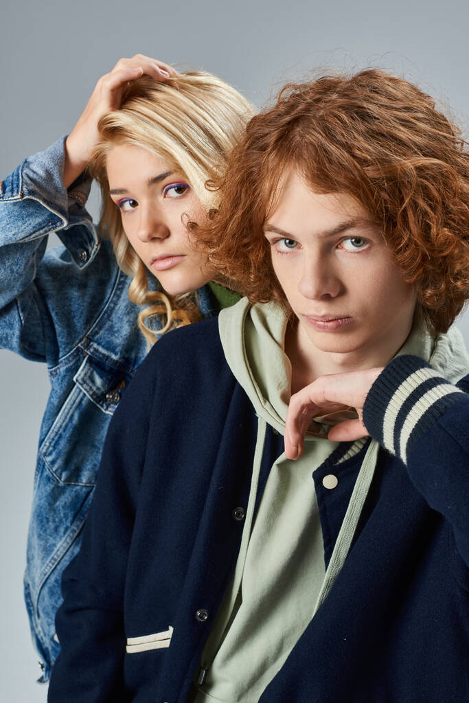 confiante adolescentes amigos em roupas casuais elegantes olhando para a câmera em cinza, moda jovem - Foto, Imagem