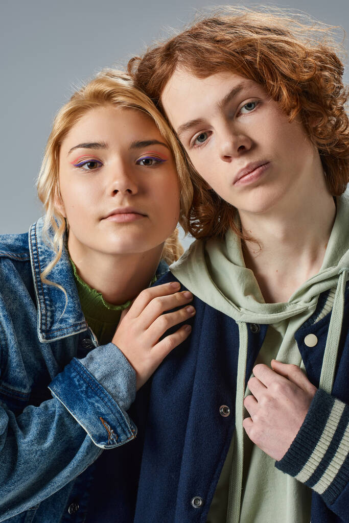 портрет підліткових моделей в модному повсякденному вбранні, дивлячись на камеру на сірому, дружбу і єдність - Фото, зображення