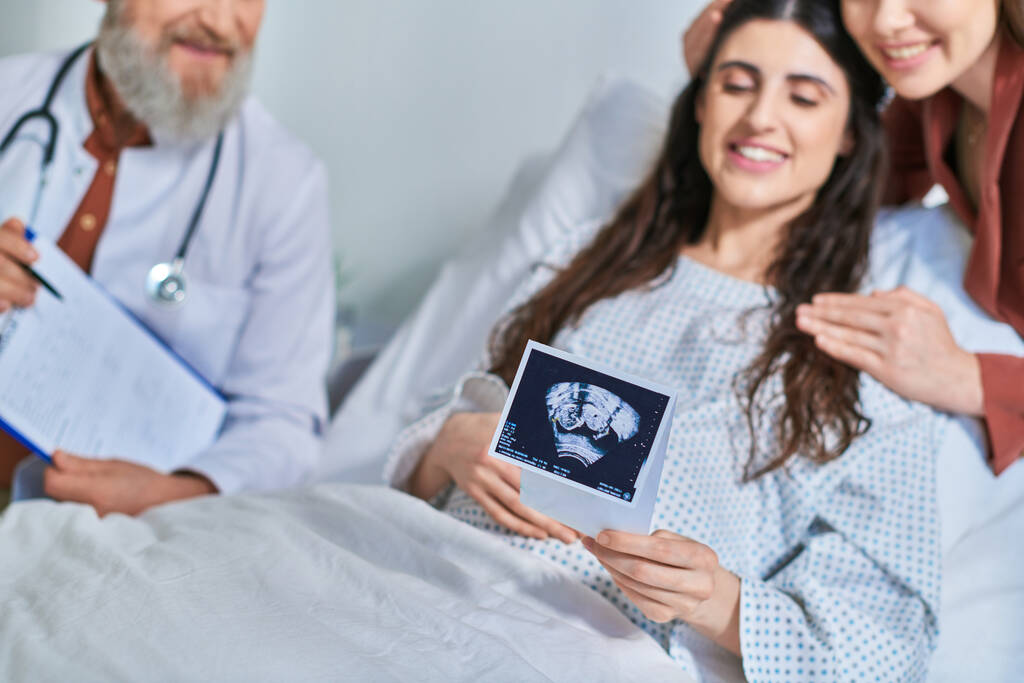 cropped view of happy lesbian couple looking at ultrasound with doctor next to them, ivf concept - Photo, Image