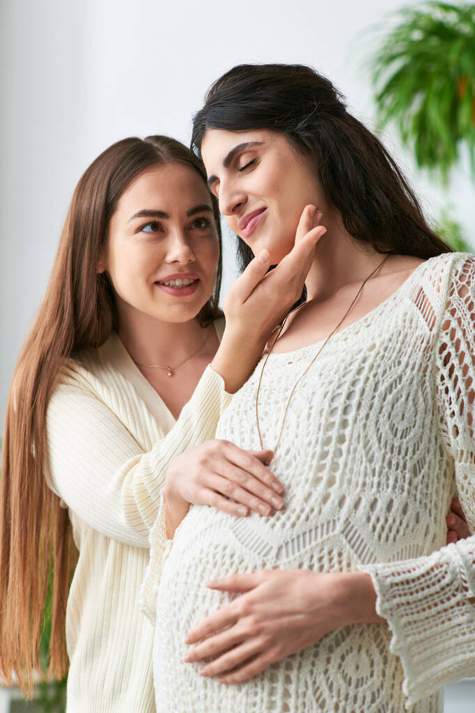 happy lgbt couple smiling cheerfully with hands on pregnant belly, hand to chin, ivf concept - Photo, Image