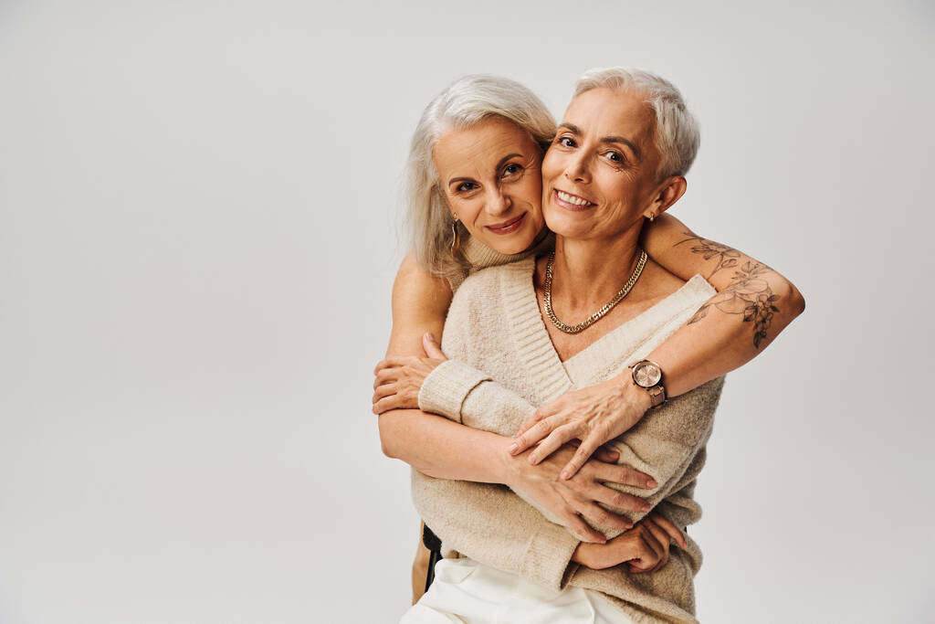 módní tetované žena objímání starší potěšený fena přítel na šedý, pozitivní životní styl - Fotografie, Obrázek
