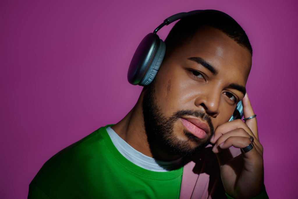 good looking african american man posing with headphones looking at camera, fashion concept - Photo, Image