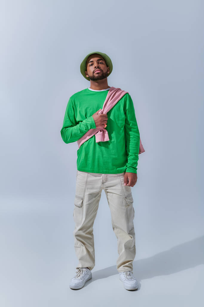 junge trendige männliche Modell in Freizeitkleidung mit Sweatshirt auf den Schultern gebunden, Modekonzept - Foto, Bild