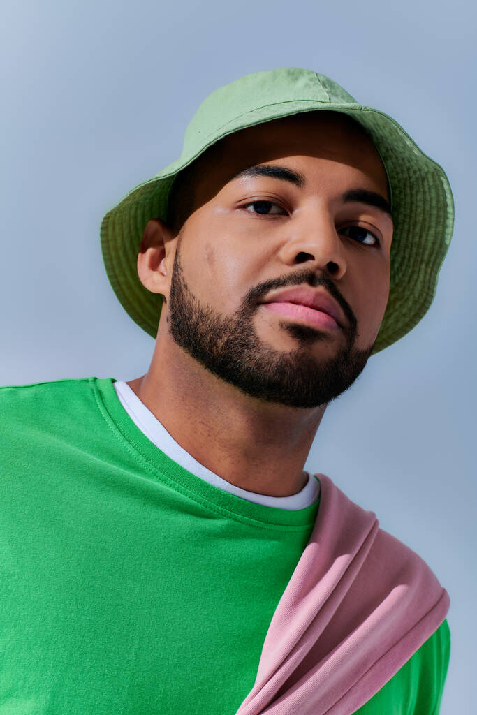 portrait de jeune homme beau avec barbe en panama vert regardant caméra, concept de mode - Photo, image