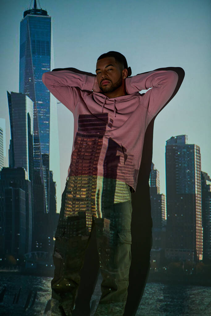 bell'uomo afroamericano in piedi vicino al muro con le mani incrociate dietro la testa, concetto di moda - Foto, immagini
