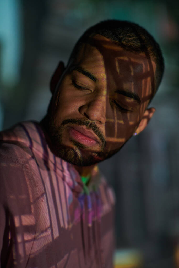 portrait de jeune homme élégant avec barbe regardant loin dans les projecteurs numériques, concept de mode - Photo, image