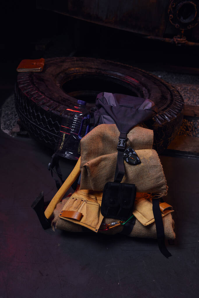 タイヤ,斧,水瓶の近くの毛布が付いているバックパック,放棄された地下鉄,黙示録的な生存 - 写真・画像