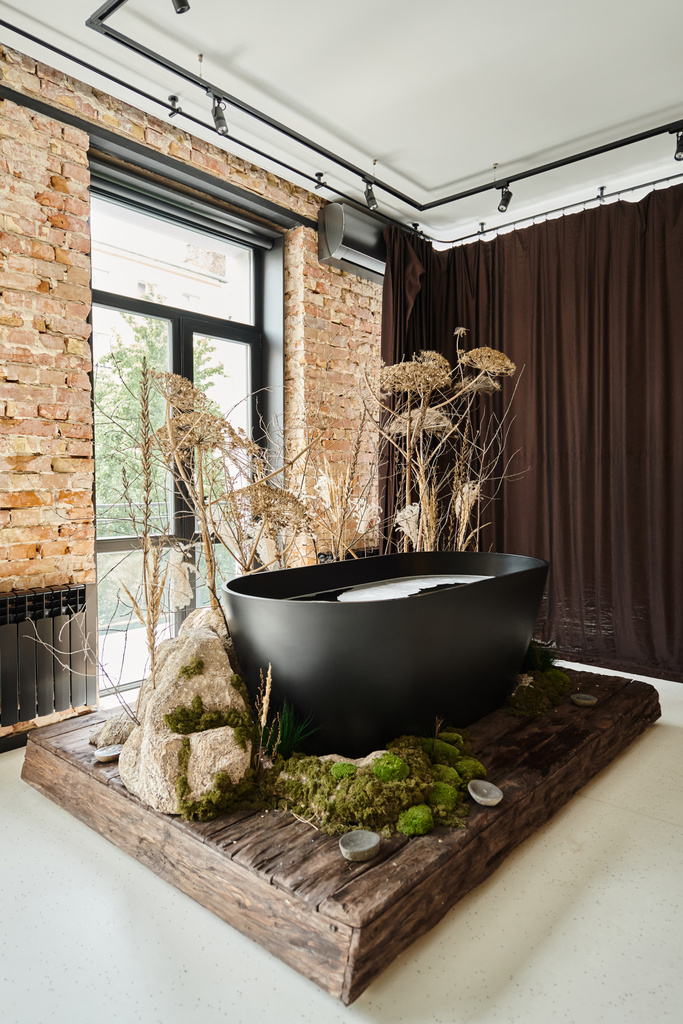 パノラマウィンドウと装飾的な植物と金型を備えたモダンなアパートの内部の黒いバスタブ - 写真・画像
