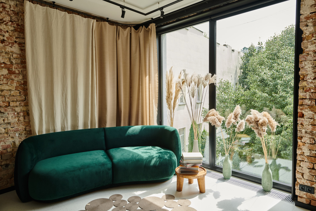 moderno apartamento con sofá de terciopelo azul, libros sobre mesa de café y ventanas panorámicas, contemporáneo - Foto, imagen