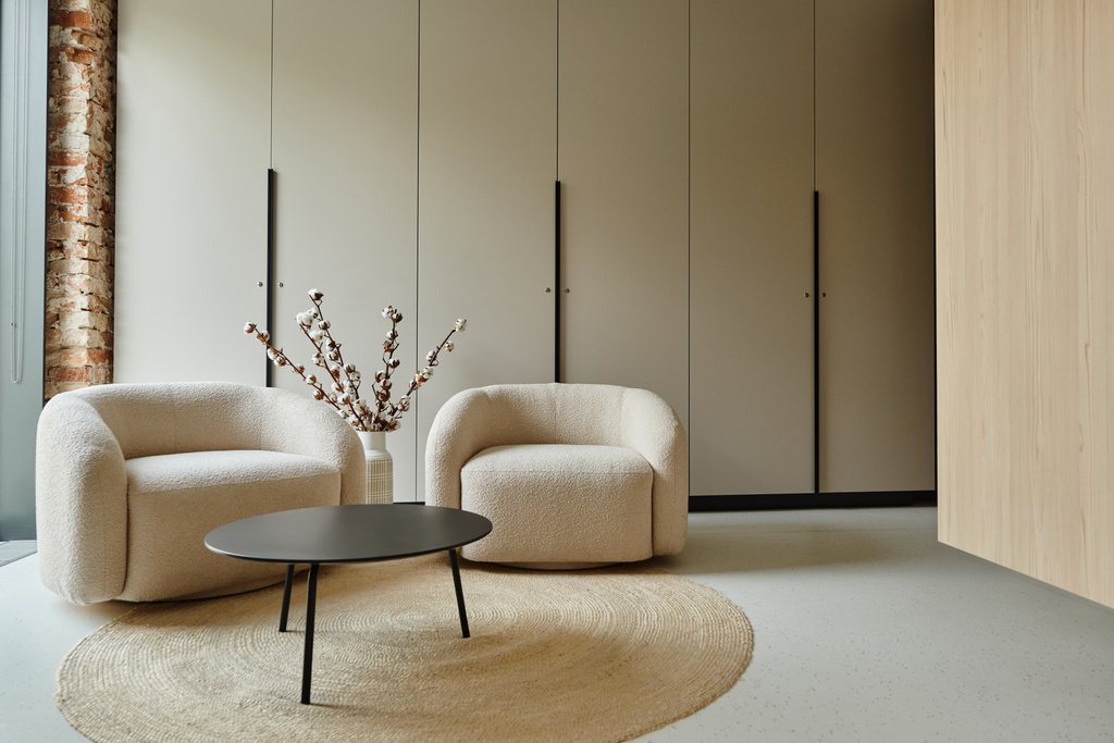 deux fauteuils blancs confortables à côté de la table basse et des branches de coton dans un vase, salon moderne - Photo, image