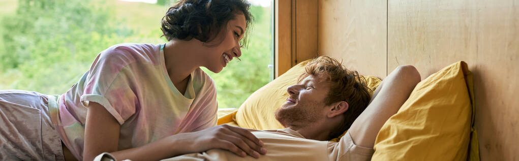 happy asian woman looking at boyfriend, interracial couple waking up in country house, banner - Photo, Image