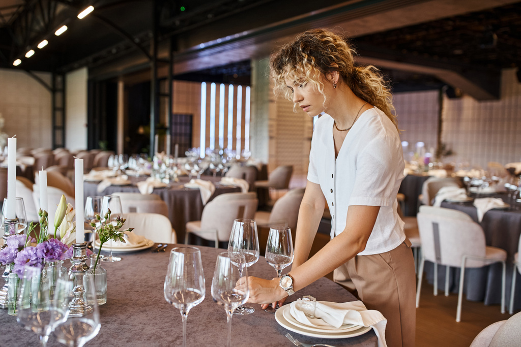 mulher com cabelo ondulado colocando óculos na mesa com ambiente festivo, coordenador do banquete no trabalho - Foto, Imagem