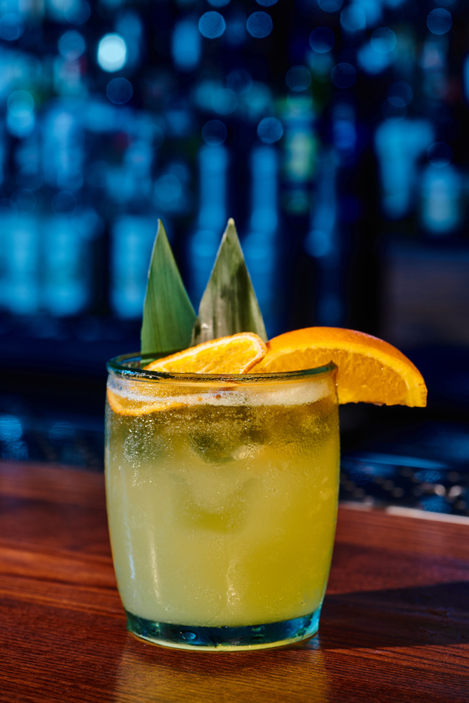 bicchiere di cocktail vecchio stile con fetta di arancia con bar sullo sfondo, concept - Foto, immagini