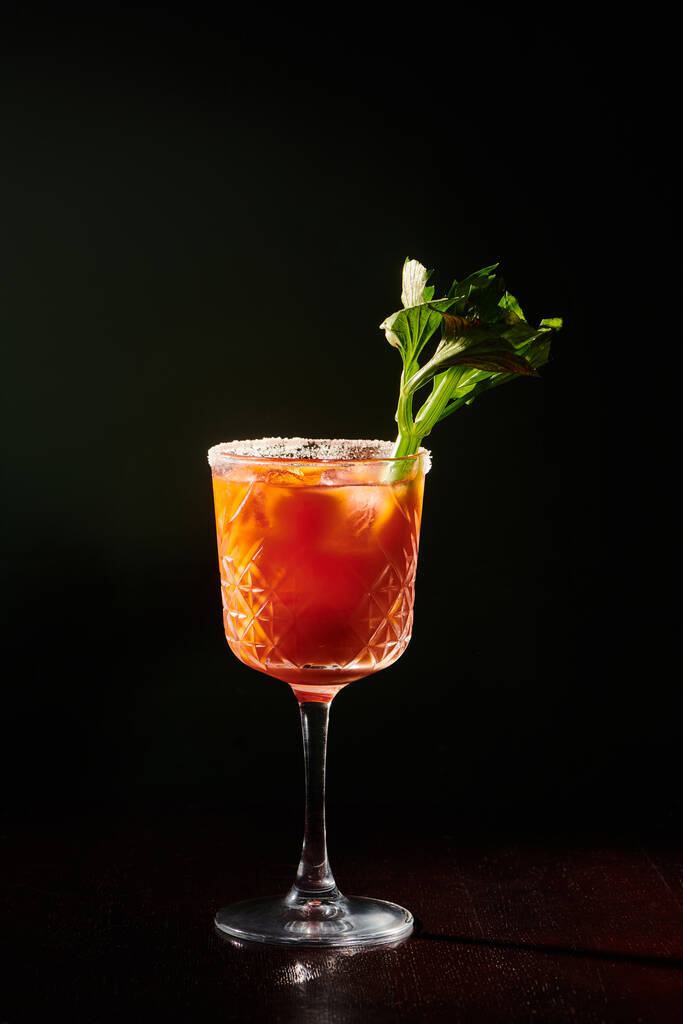 prachtige Bloody Mary cocktail met selderij stengel garnering op zwarte achtergrond, concept - Foto, afbeelding