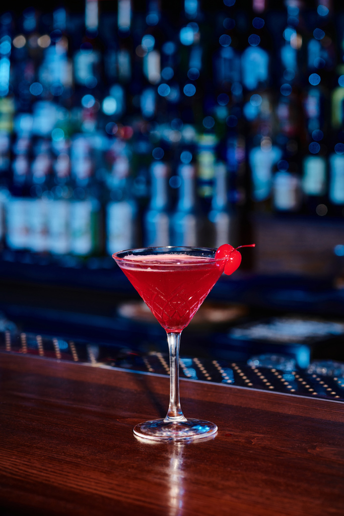 Eleganter kosmopolitischer Cocktail im Martini-Glas mit Kirsch an der Theke, Konzept - Foto, Bild