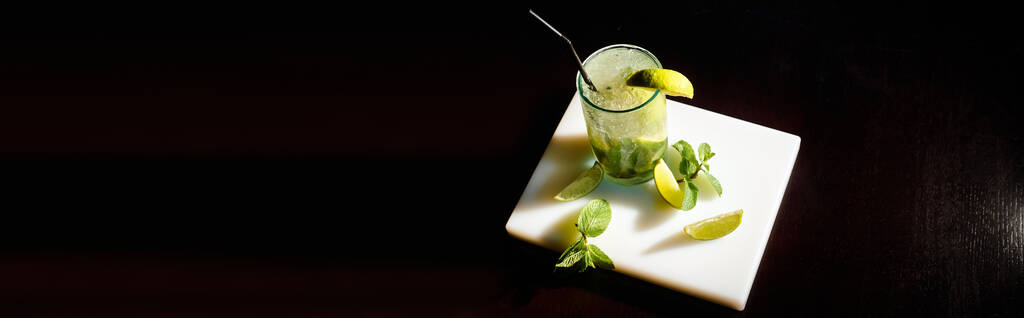 top view of mojito cocktail with ice cubes and mint on black backdrop, concept, banner - Photo, Image