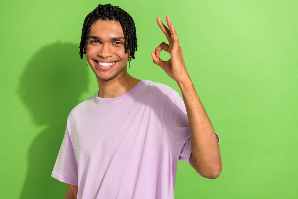 Portret van grappige koele jonge man tonen oke symbool aanbevelen uiten goedkeuring geïsoleerde groene kleur achtergrond. - Foto, afbeelding