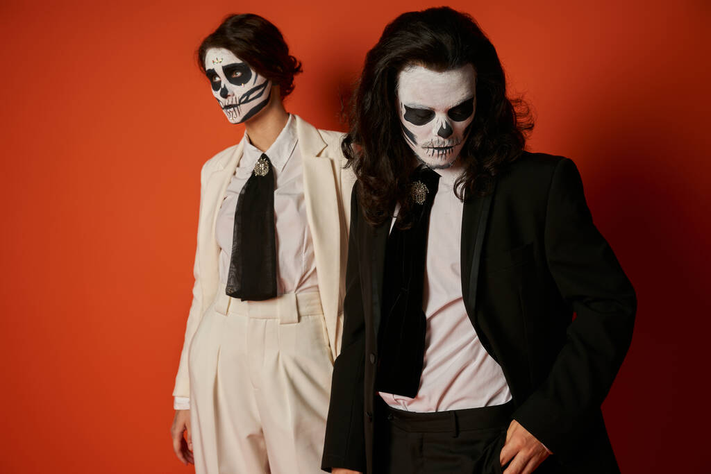 casal em açúcar assustador crânio maquiagem e ternos preto e branco no vermelho, dia de muertos perdidos fest - Foto, Imagem