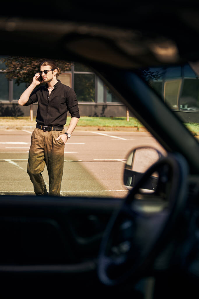 bell'uomo con look elegante con mano in tasca parlando per telefono con l'assicuratore auto, autista sexy - Foto, immagini