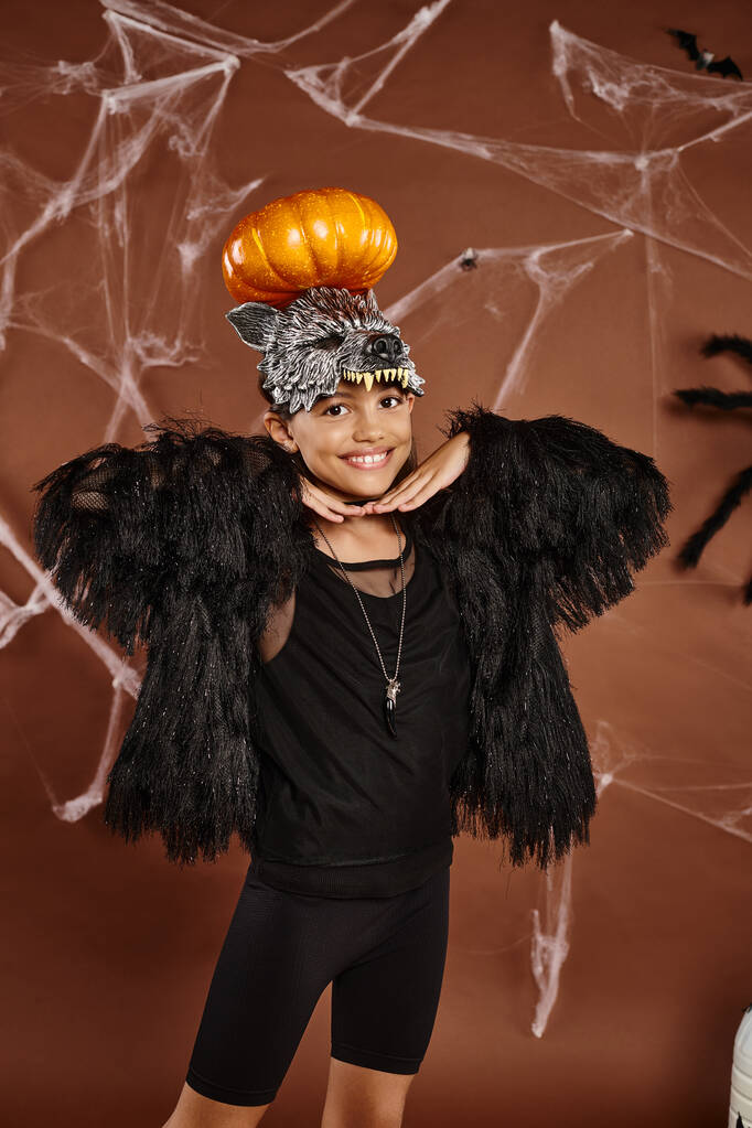 zbliżenie uśmiechnięta nastolatka dziewczyna z dyni na głowie i ręce pod brodą, Halloween - Zdjęcie, obraz