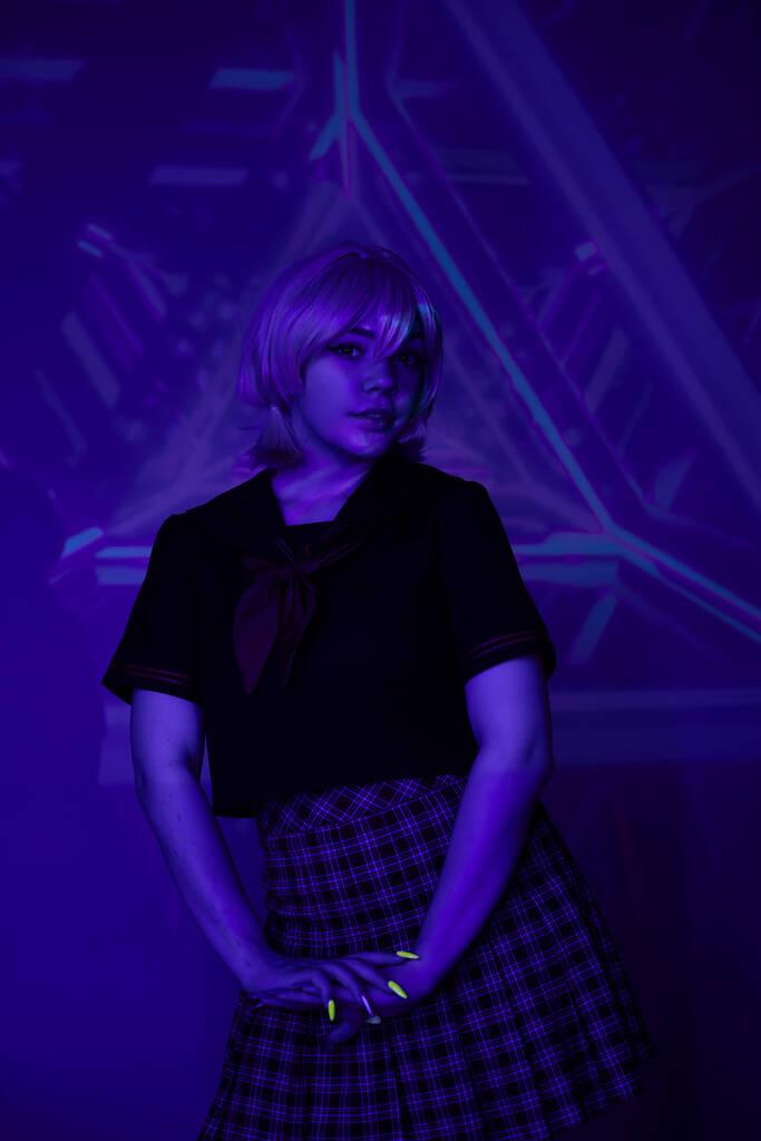 fiatal szőke nő iskolai egyenruha neon fény kék elvont háttér, cosplay karakter - Fotó, kép
