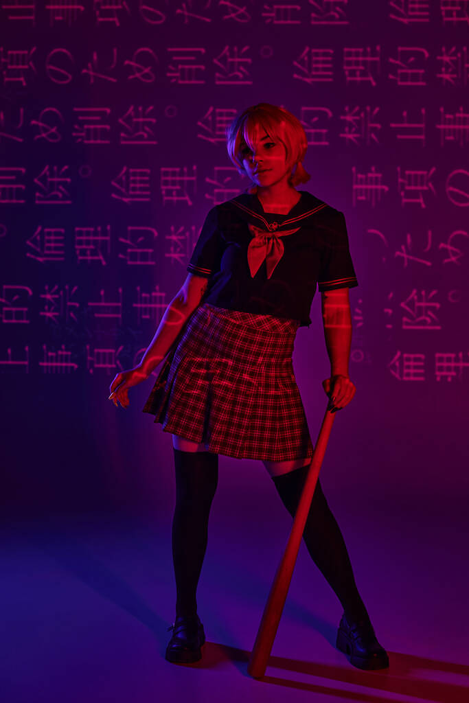 cosplay nő iskolai egyenruhában áll baseball ütő neon lila háttér hieroglifák - Fotó, kép