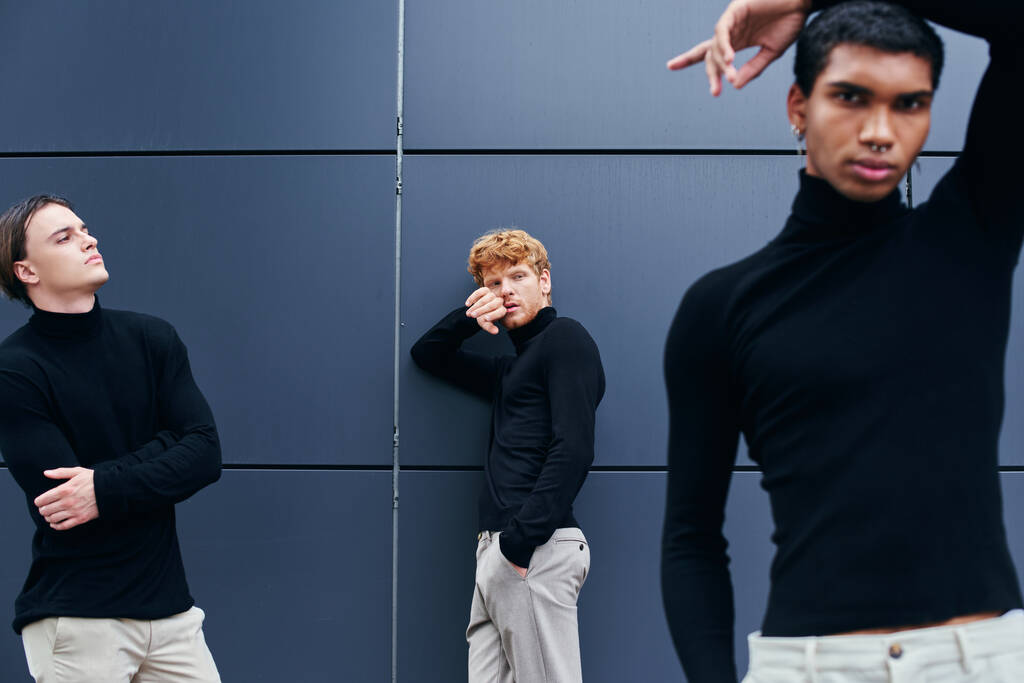 bel gruppo interrazziale di uomini in posa accanto al muro in dolcevita nero casual, moda - Foto, immagini