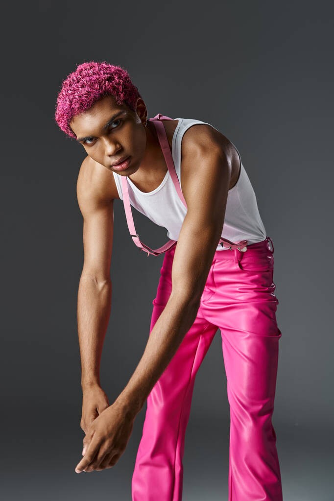 ピンクの髪のトレンディな男性モデルは少し前方に傾き,カメラ,ファッション,スタイルを見ています - 写真・画像