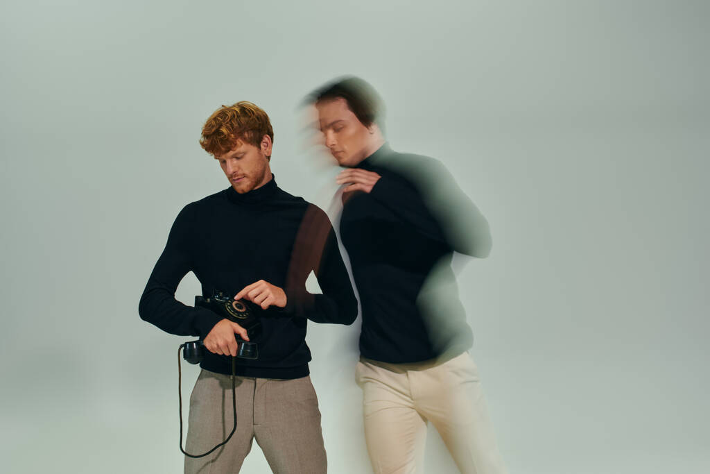 Langzeitbelichtungsfoto von zwei jungen Männern in eleganten Rollkragenpullovern, die mit Retro-Telefon posieren, Modekonzept - Foto, Bild