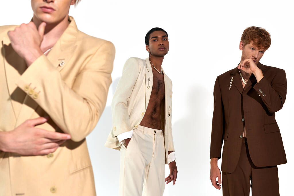 cropped view of three young diverse men posing in classy vivid suits on white backdrop, fashion - Photo, Image