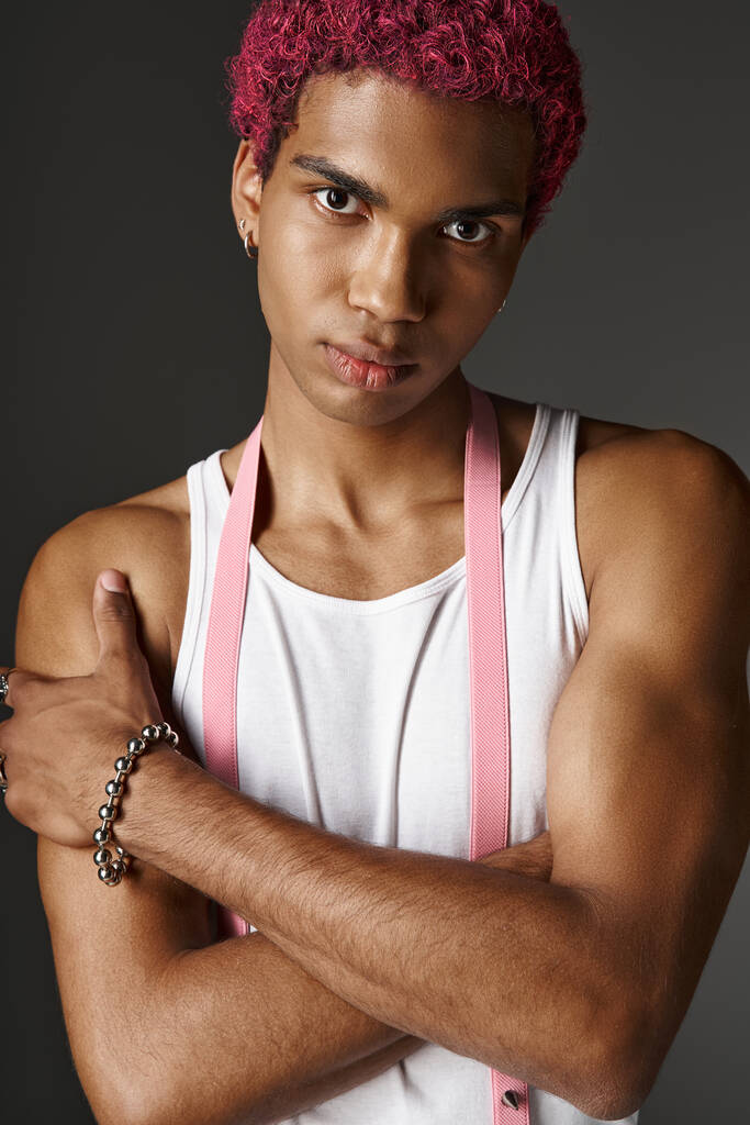 портрет молодого стильного чоловіка з рожевим волоссям, позує з трохи схрещеними руками, концепція моди - Фото, зображення