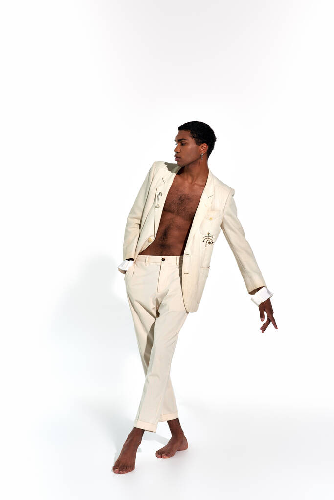 atractivo hombre afroamericano sexy en traje elegante en movimiento sobre fondo blanco, concepto de moda - Foto, imagen