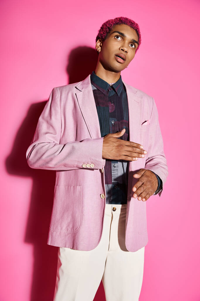 good looking man acting unnaturally like male doll wearing pink blazer on pink backdrop, doll like - Photo, Image